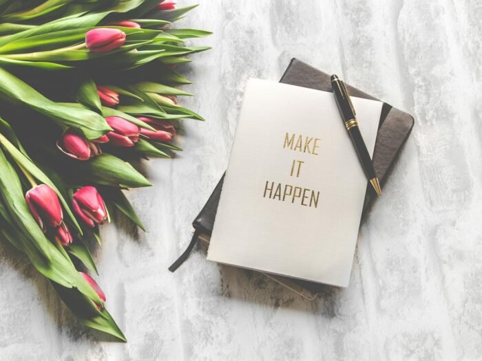 Un carnet de note où il est écrit Make it Hapen